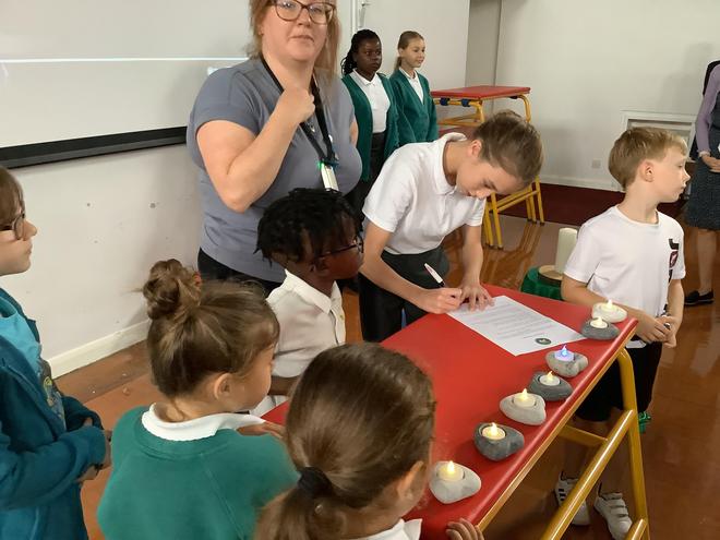A pupil from each class comes forward whilst we sing and signs the behaviour charter on behalf of their class.